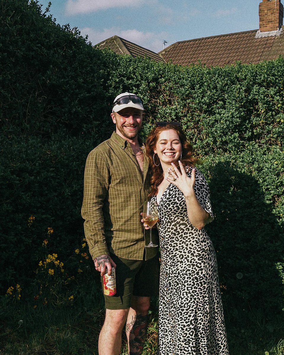 The couple in the garden, showing off the engagement ring